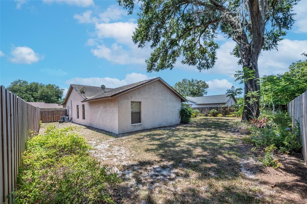 The yard is completely fenced with a gate on both sides leading to the front yard.