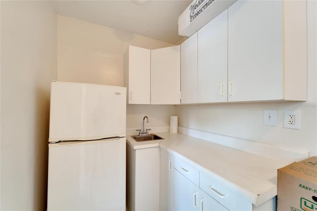 Kitchenette with sink and fridge.