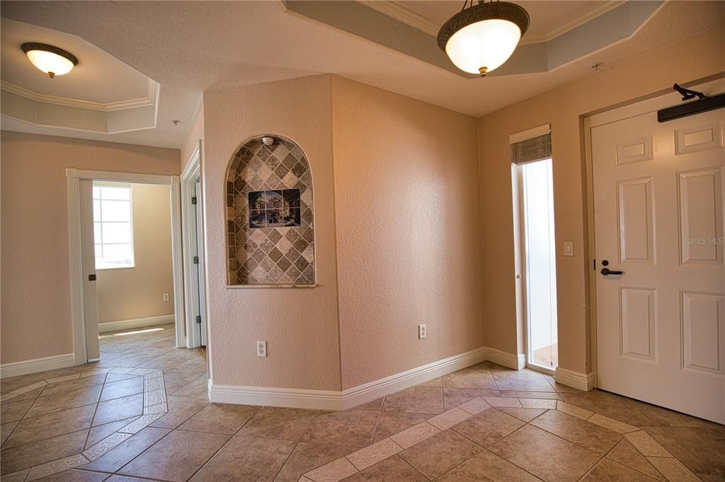 Classy entrance and a real foyer, with tray ceiling and custom tile work flooring