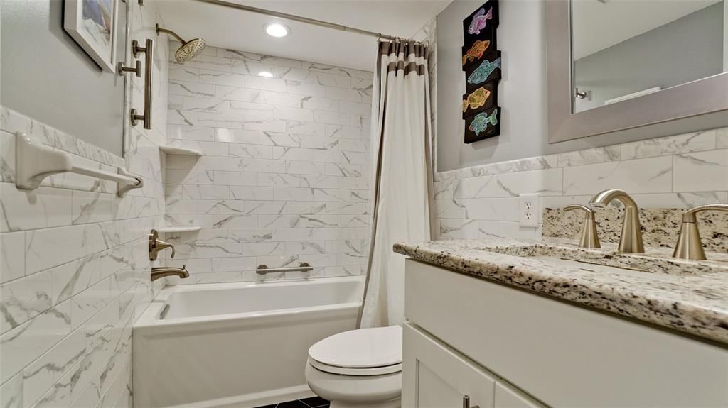 SECOND BATHROOM ALSO UPDATED WITH GRANITE TOP VANITY, MIRROR, TILED SURROUND BATHTUB