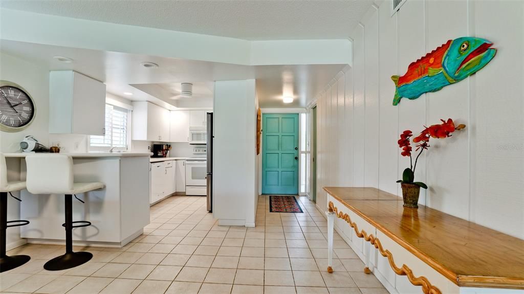 COLORFUL TURQUISE ENTRY DOOR & A COAT CLOSET ON THE RIGHT HAND SIDE OF ENTRY HALL