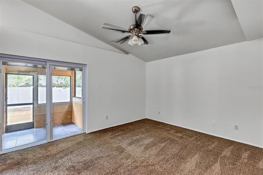 Carpeted primary suite-vaulted ceiling with sliding doors (built in blinds)