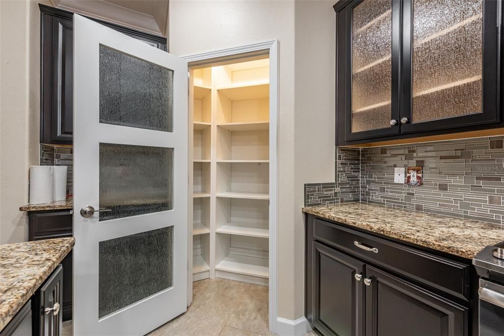 Here's a closer look at the pantry with upgraded shelving and separators instead of wire racks and goes way up high for lots of extra storage. The door has matching rain glass as the cabinets.