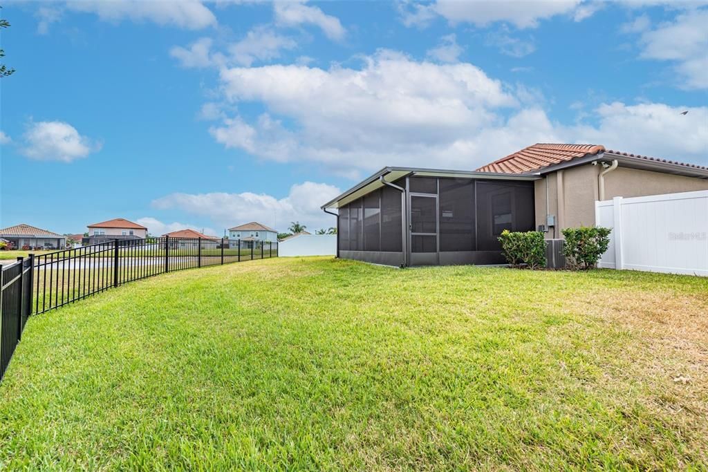 Fully fenced backyard with 6' vinyl fencing from the back of the house and along sides and aluminum fencing across the back.  Woods and pond view from the rear of the house and porches.