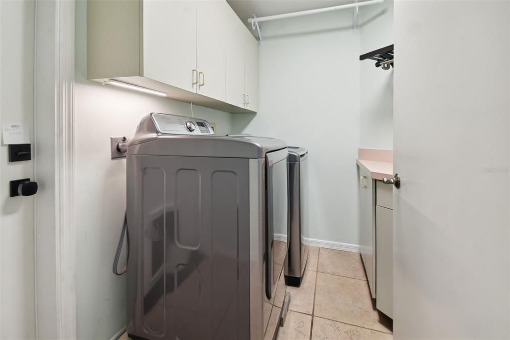 Inside laundry room with folding area and storage.