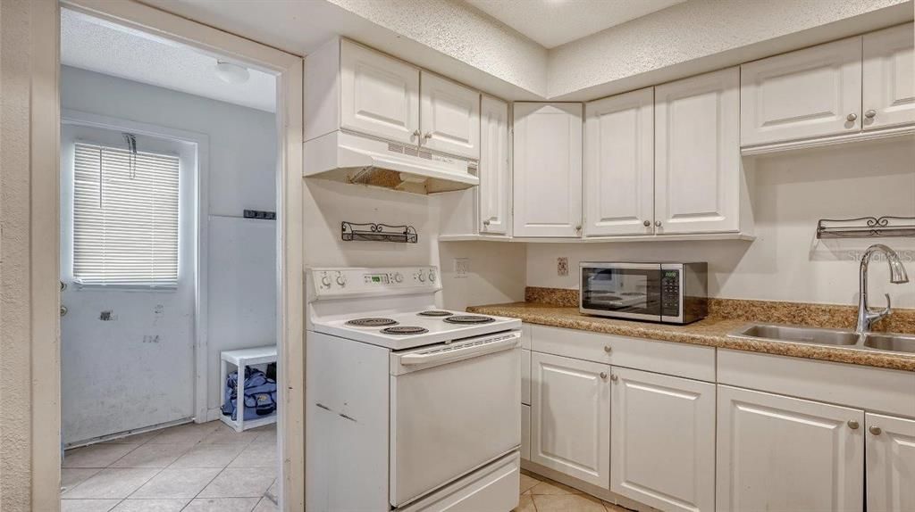 Kitchen featuring ample cabinetry, solid surface countertops, and a breakfast bar.