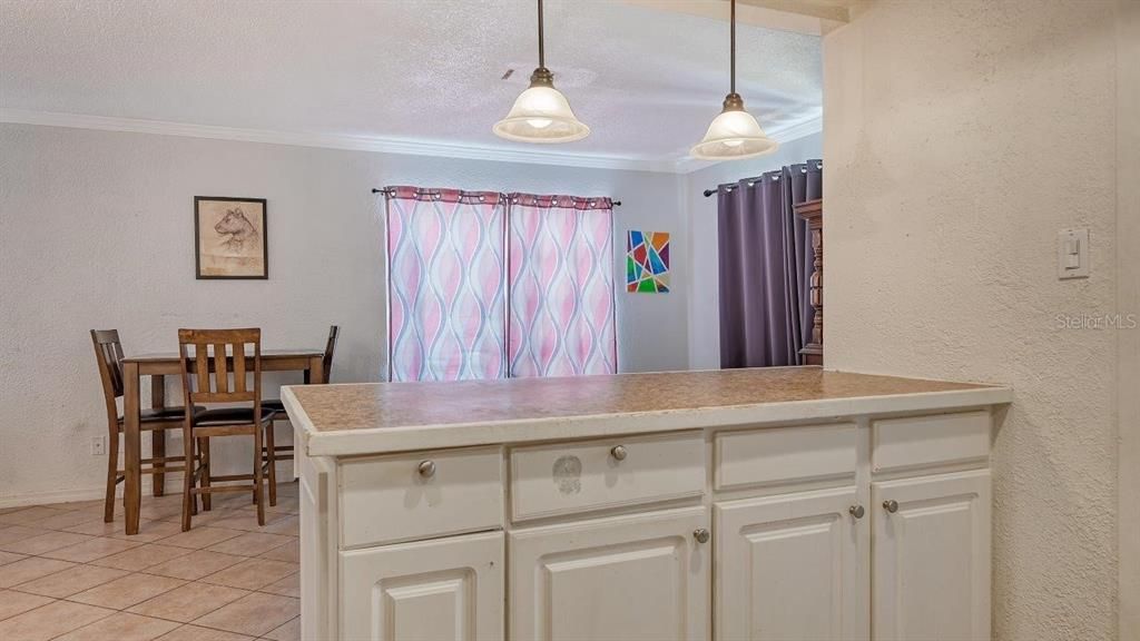 Kitchen featuring ample cabinetry, solid surface countertops, and a breakfast bar.