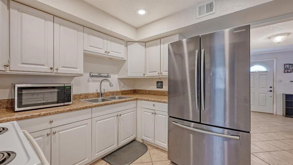 Kitchen featuring ample cabinetry, solid surface countertops, and a breakfast bar.