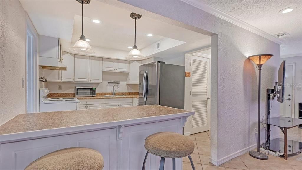 Kitchen featuring ample cabinetry, solid surface countertops, and a breakfast bar.