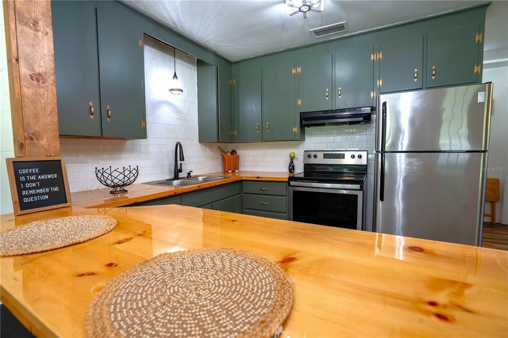 KITCHEN HAS WHITE SUBWAY TILES AS THE BACK SPLASH