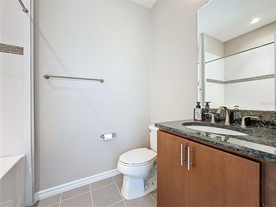 Guest bath with oversized tub, tiled wall with designer listello