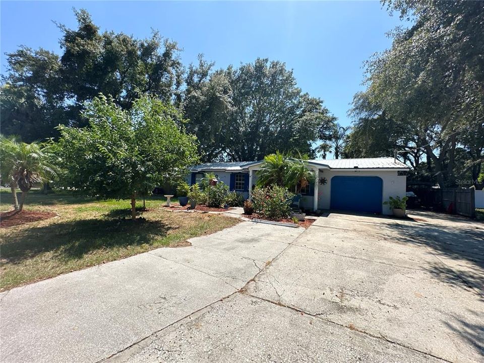 Wide driveway with single car garage and separate car port