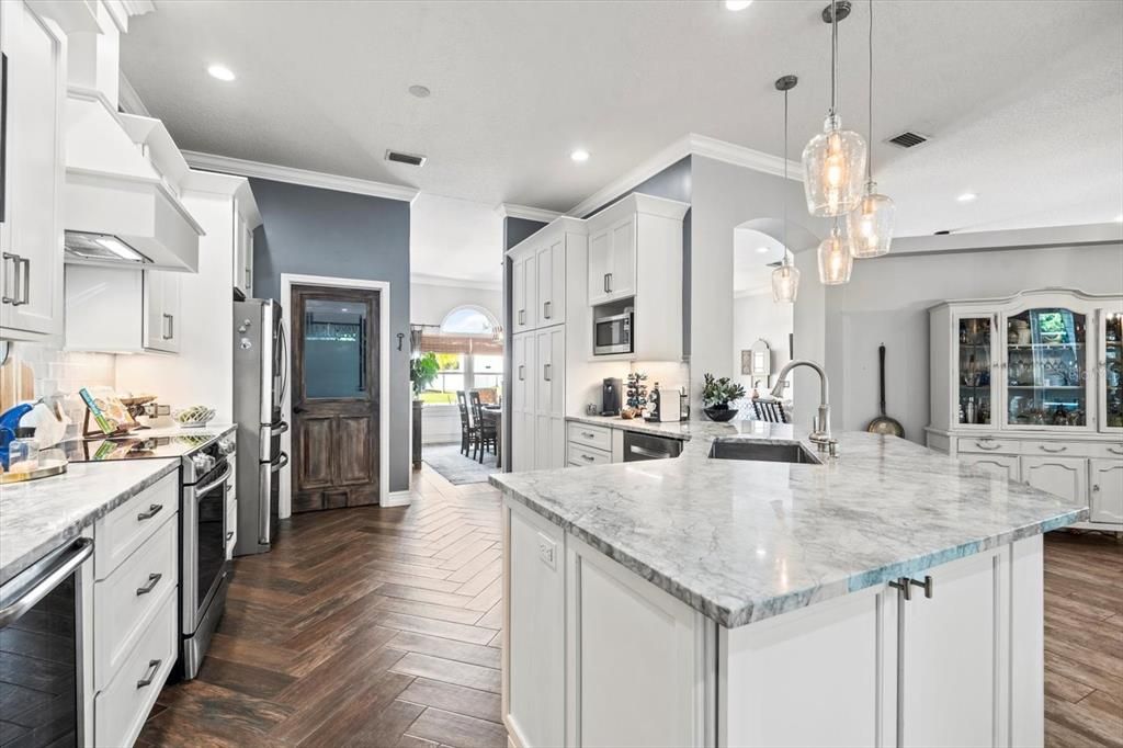 Remodeled kitchen features farmhouse sink, quatzite countertops, soft close cabinets, built in pantry, and a wine fridge.