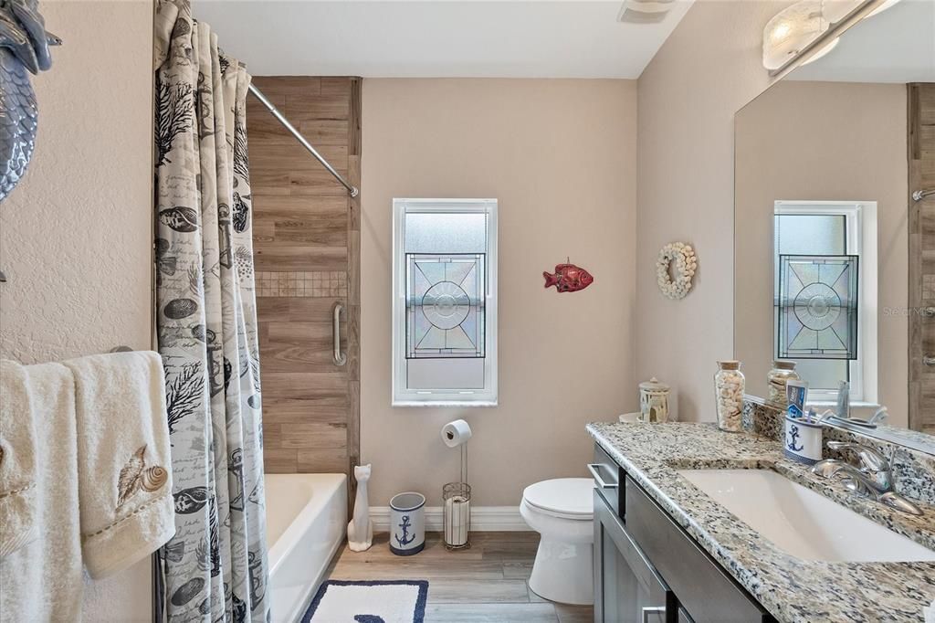 Bath #2 is accented with granite and upgraded tile in the tub/shower