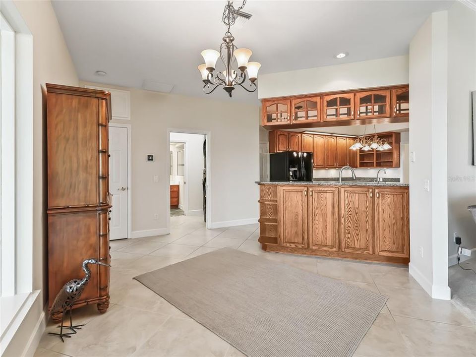 From sunroom entrance, looking toward the front of the home and showing the kitchen bar eating area