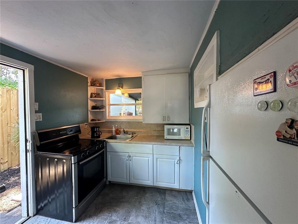 Kitchen with side exterior leading to yard and laundry