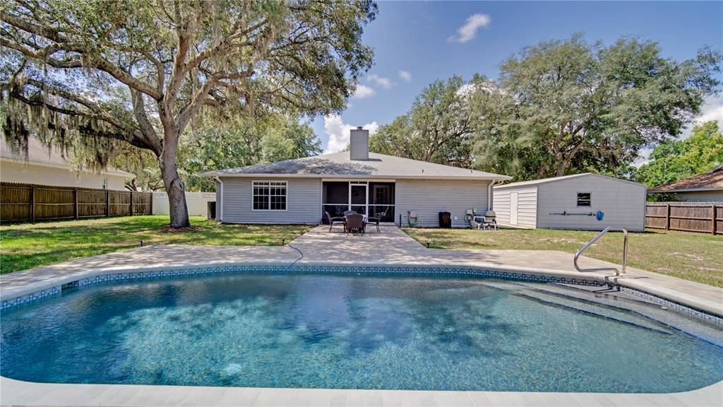 Backyard view of pool and pavers