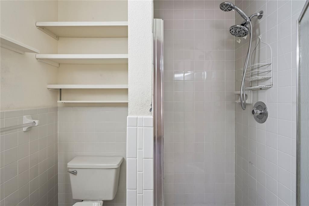 Primary bath has the shower, shelves for towel, etc.