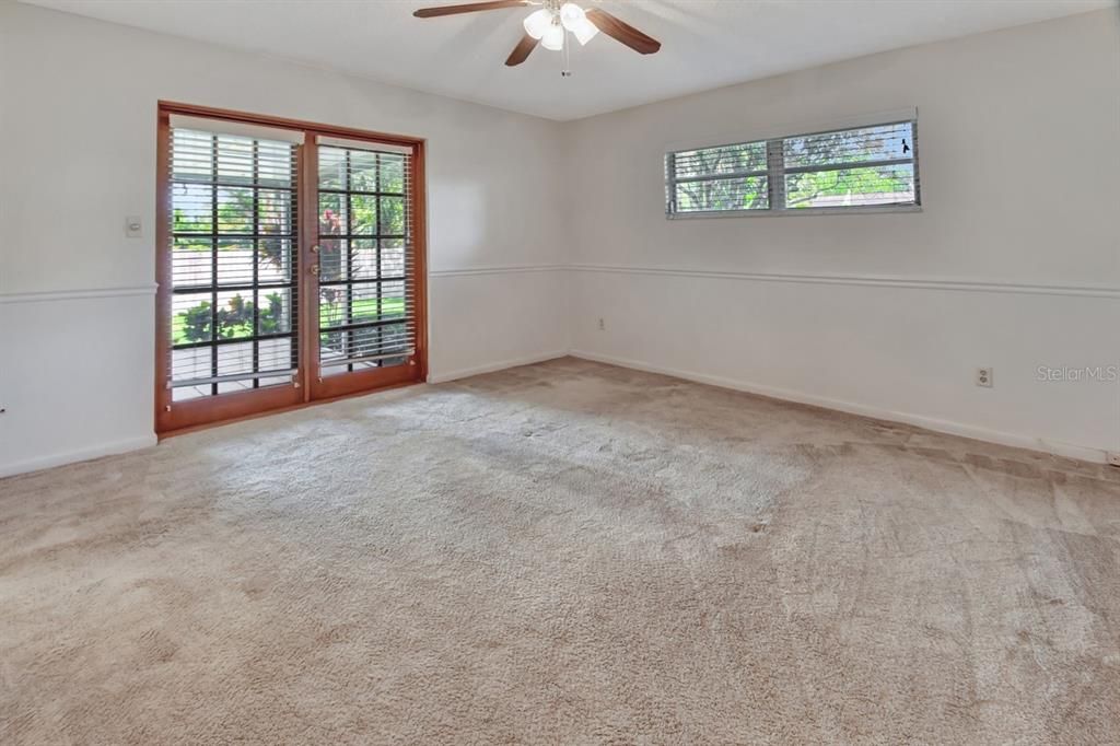 Primary bedroom French doors lead to the screened in rear porch