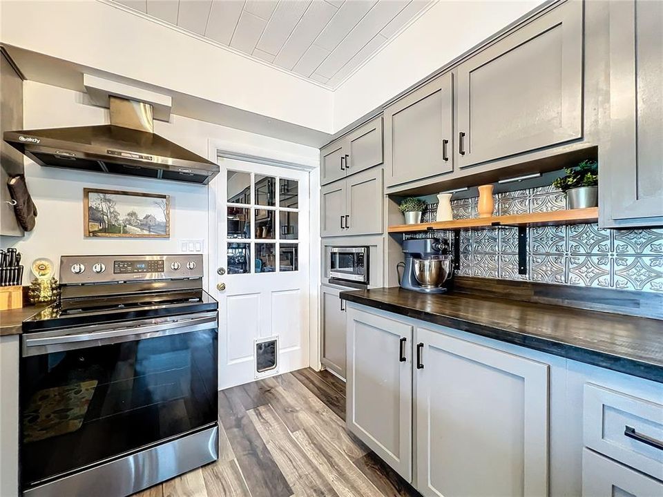 Stainless Steel Range w/Large Exhaust Hood, & entry to garage & laundry room