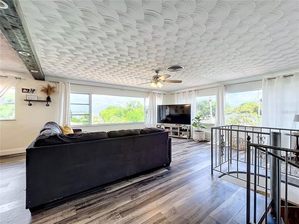 Connected Living Room with Large Picture Windows, Artistic Ceiling & Cast Iron Spiral Staircase