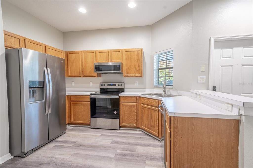 The kitchen features recessed lighting, wood laminate flooring (2023) , wood tone cabinets and plenty of counter space.