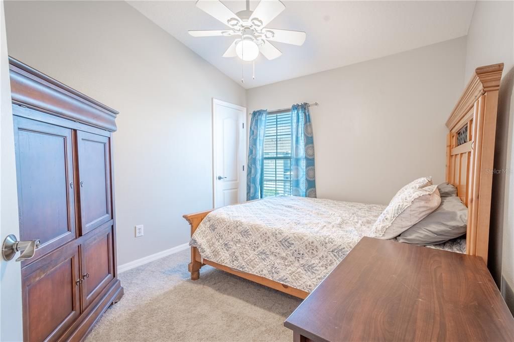 Bedroom 3 features plush carpet, neutral tones, a ceiling fan with light fixture and built-in closet.