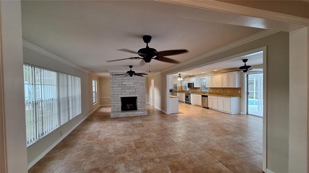 Foyer view of living, kitchen, fireplace