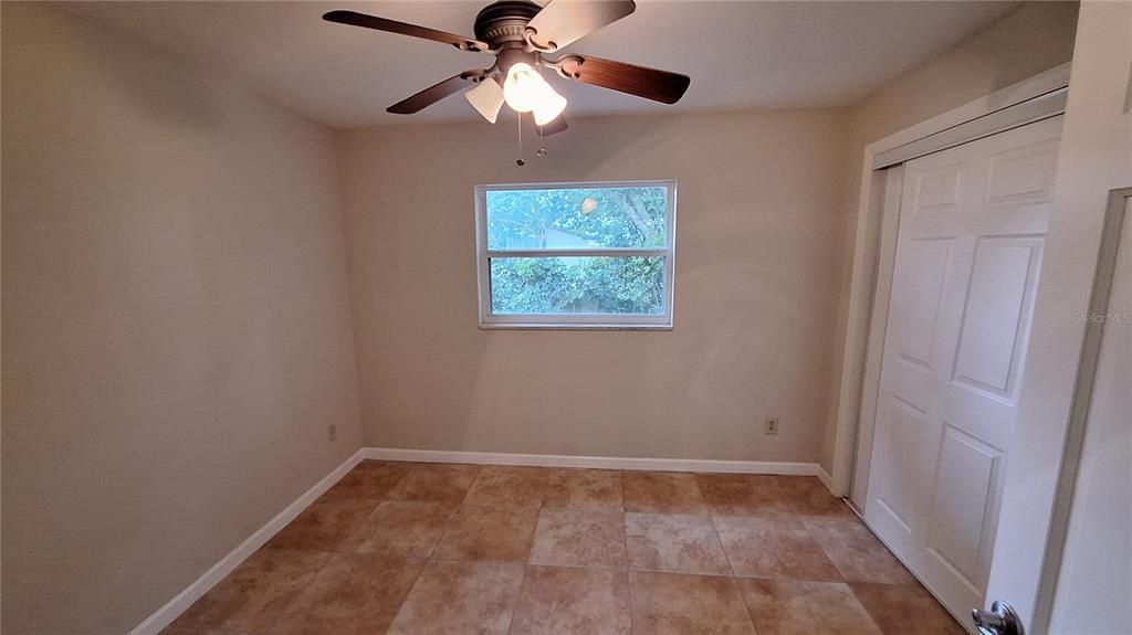 Primary bedroom with ceiling fan and 2 closets