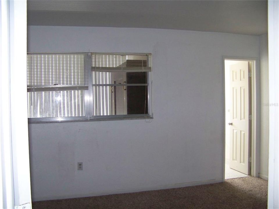 Primary Bedroom. South facing. Window overlooks bonus Florida Room. Doorway to primary bath with updated shower