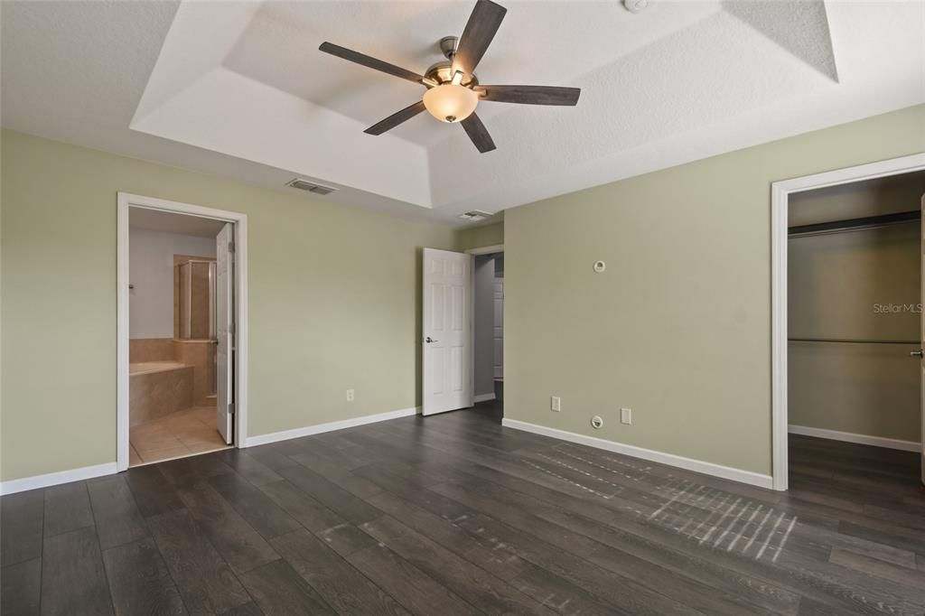 Large Master bedroom featuring tray ceilings