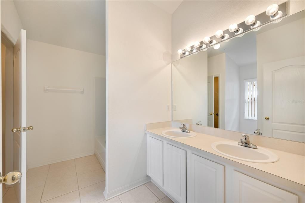 master Bathroom with dual sinks, tub/shower combo and a private water closet to the left