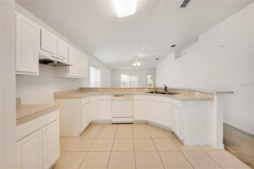 Kitchen with spot to left for range and a breakfast bar and sink straight ahead