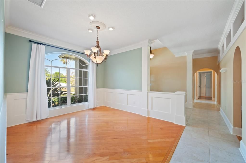 Lovely Dining Area with gleaming wood floors and large window looking out to front yard