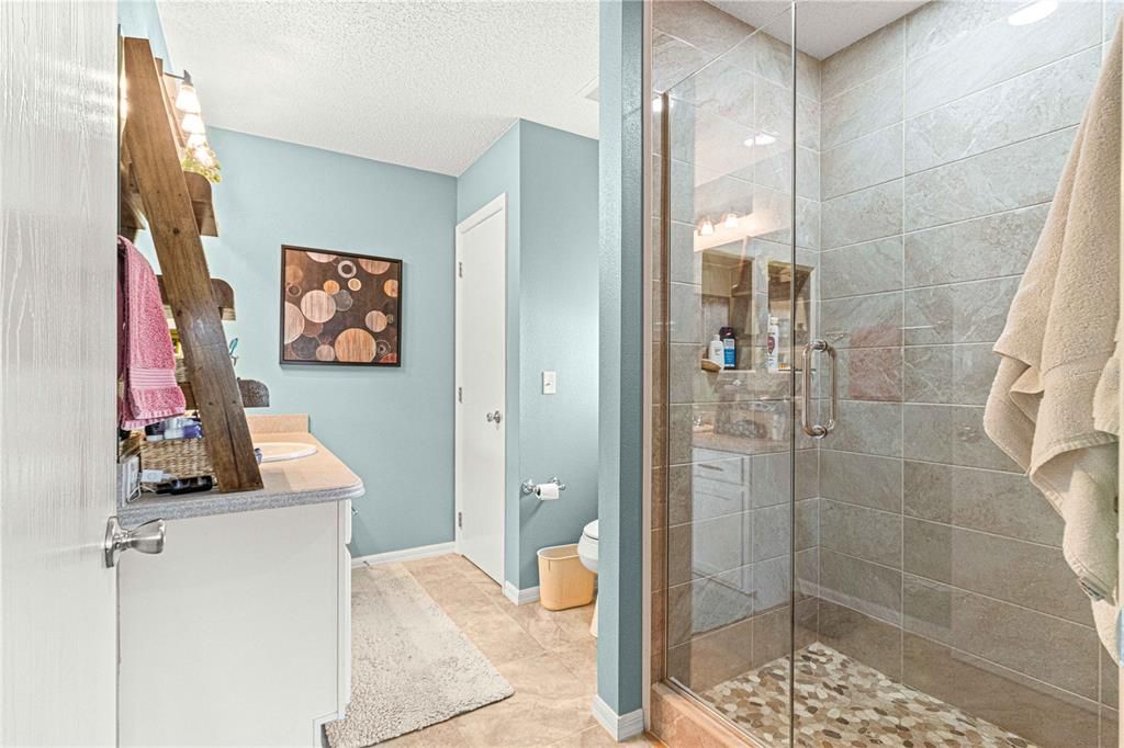 Recently Updated Tiled Walk-In Shower with Glass Door and Tile Flooring