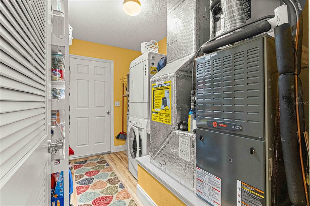Laundry Room with Stackable Washer and Dryer. Door Leads to the Two Car Garage