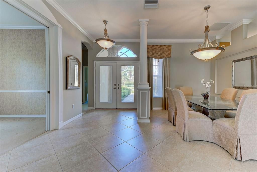 View from great room, looking into the dining room with office on the left and 2nd bedroom to the front of the home.  Transom windows and double glass front doors make allow for so much natural light.