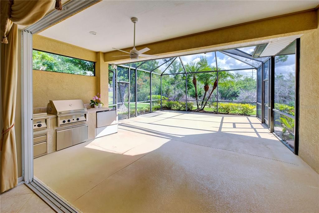 View from great room of the lanai with outdoor kitchen.  Sliders pocket, (fully open) making entertaining a delight and letting the fresh air into the home.