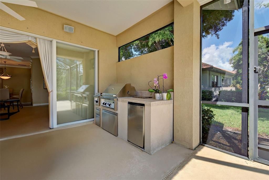 View of outdoor kitchen with lanai slider pocket doors.