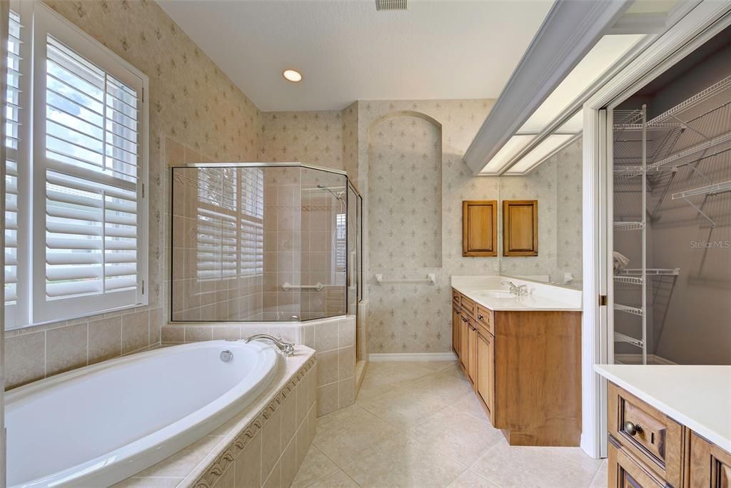 Bathroom has plantation shutters and an enormous walk-in closet.