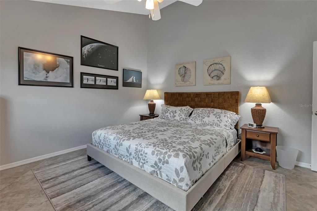 Guest bedroom 2 features porcelain tile and ceiling fan.