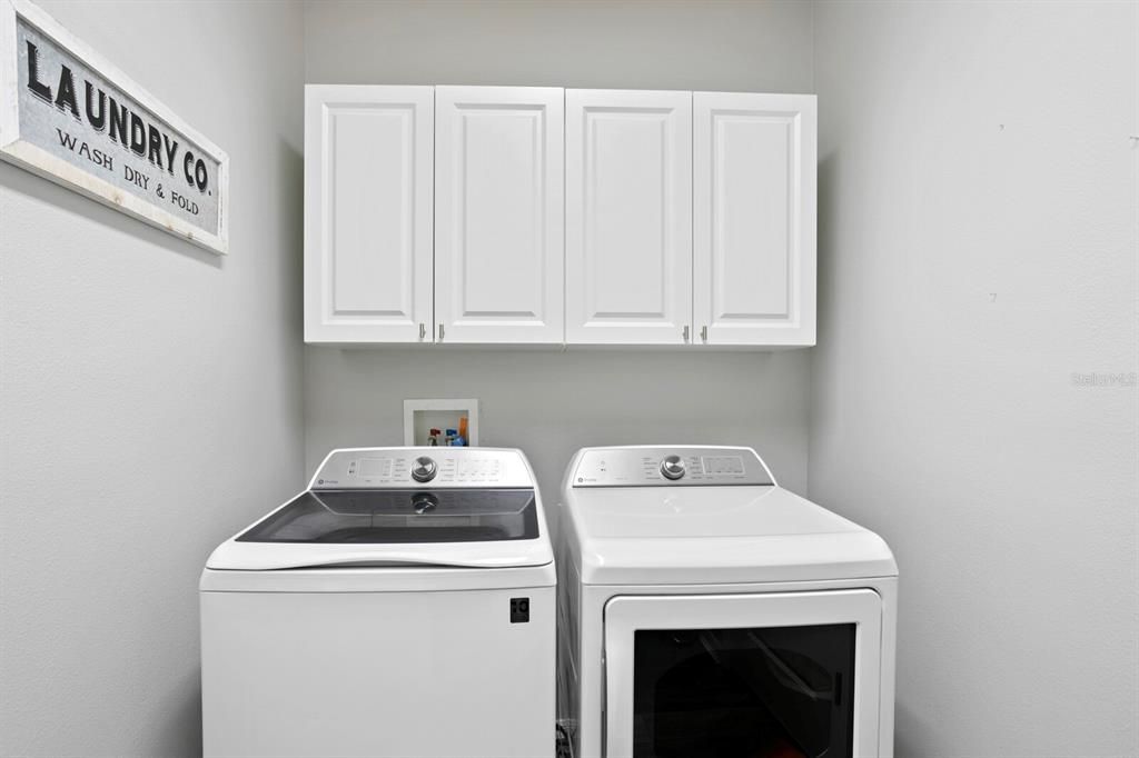 Large laundry room with additional storage that leads out the the 3-car garage