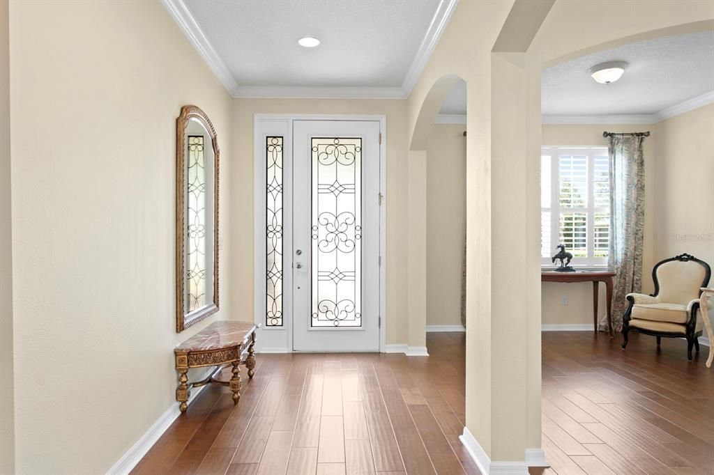 The custom glass door opens to high ceilings and a spacious foyer