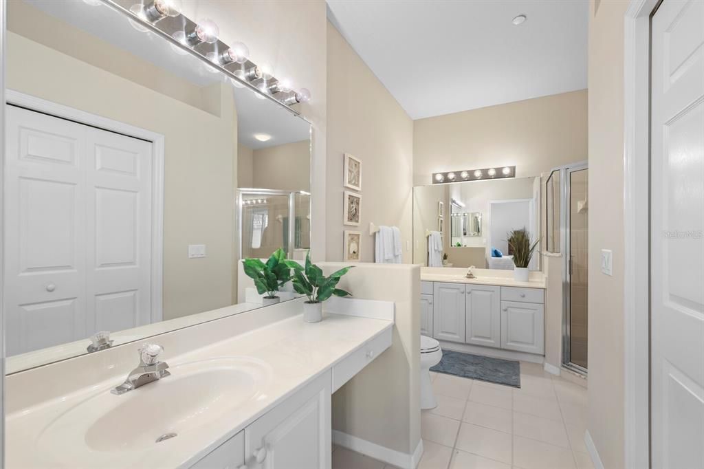 Large primary bath with two vanities, walk-in shower and walk-in closet