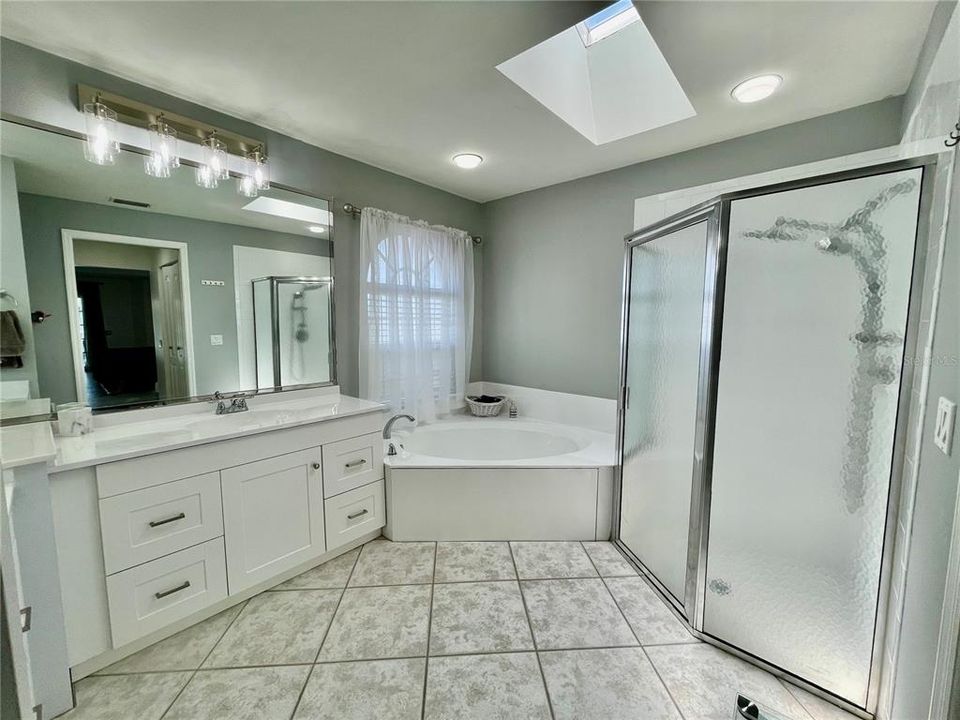 Updated master bathroom has a skylight, soaking tub and it's own hot water heater