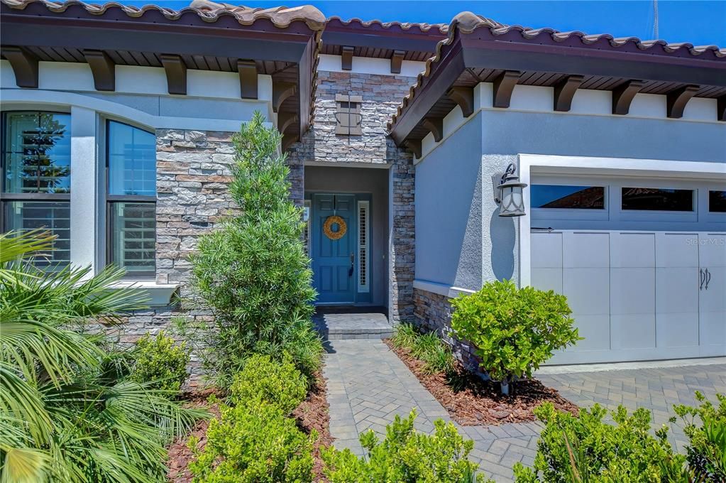 Absolutely stunning with stacked stone accents, corbels & tile roof!