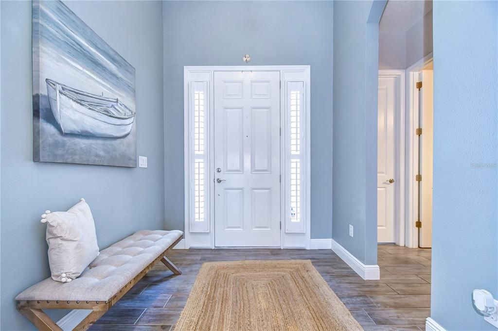 Be welcomed by wood-look tile floors, 12 foot ceilings & crown!