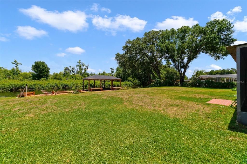 The extended screened lanai has all the outdoor space you could ask for overlooking a yard big enough to add a pool and of course your very own dock complete with a BOAT LIFT and ELECTRIC!