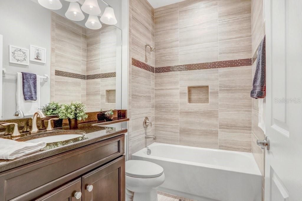 The second bathroom features an upgraded tiled tub/shower combo AND an upgraded vanity with storage.