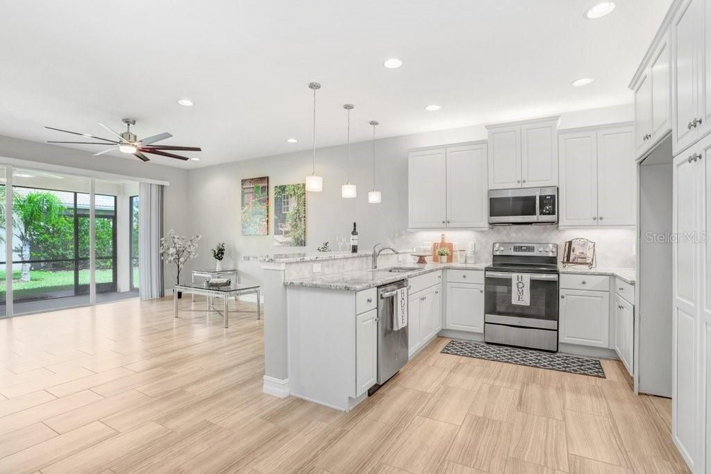 The Kitchen features a bar with overhead pendant lighting that seats up to four.... Granite countertops.... Stainless Steel appliances.... 42" SOFT CLOSE cabinets with crown molding.... and a beautiful, upgraded backsplash!